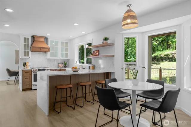 a kitchen with a table chairs sink and cabinets