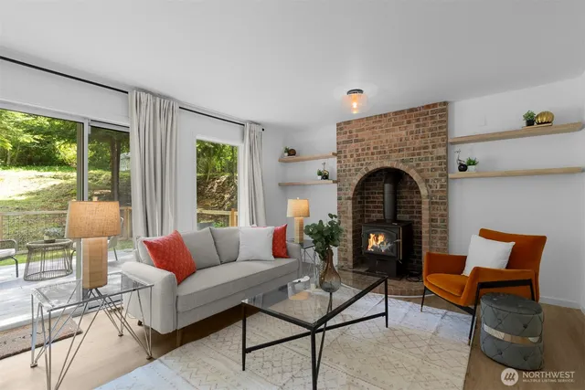 a living room with furniture a large window and a fireplace