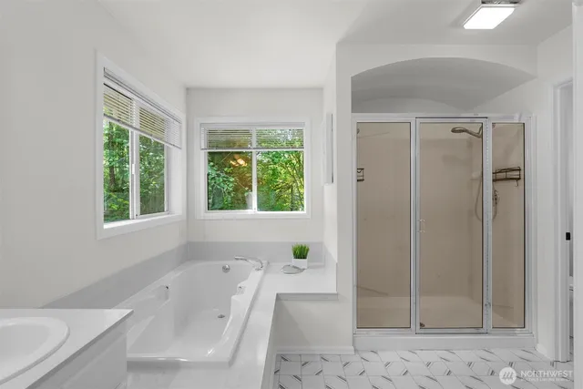 a bathroom with a tub sink and mirror