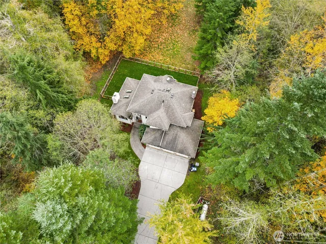 an aerial view of residential house with outdoor space and trees all around