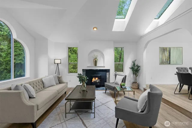 a living room with furniture a fireplace and a large window