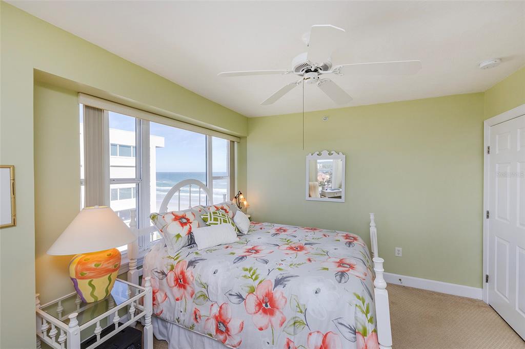 4631 South Atlantic Avenue, Unit 8601 Ponce Inlet, FL 32127 - Photo 33 of 64 a bedroom with a bed and a chandelier