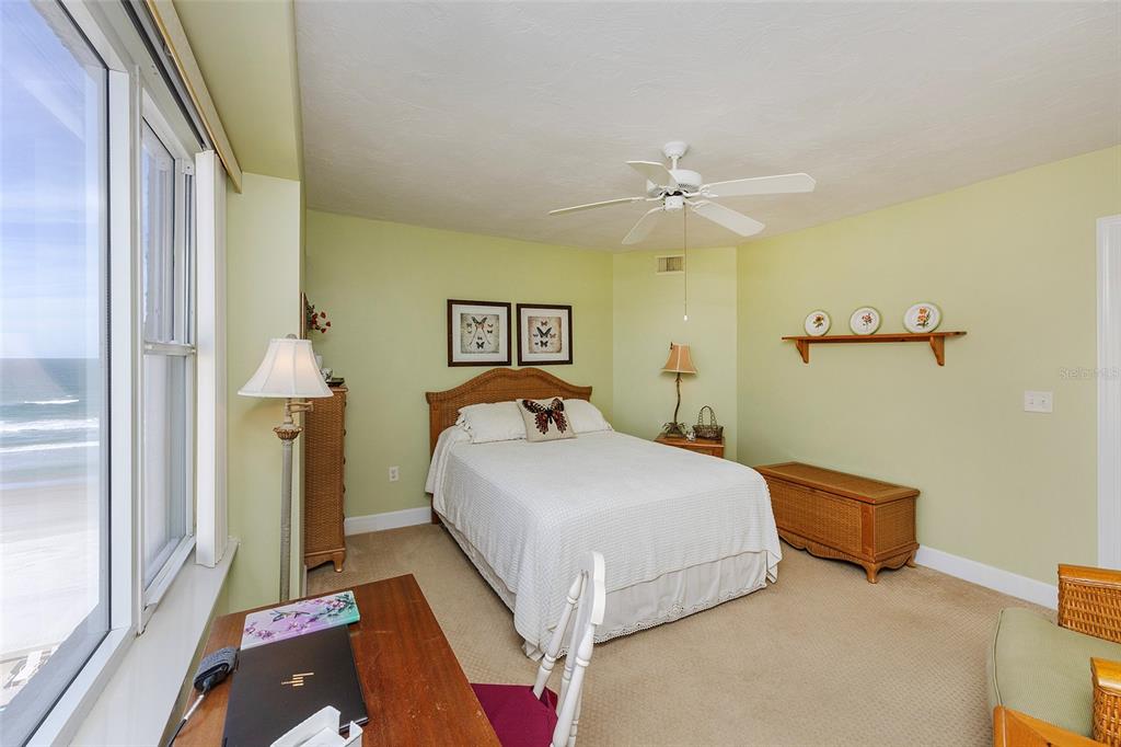 4631 South Atlantic Avenue, Unit 8601 Ponce Inlet, FL 32127 - Photo 35 of 64 a bedroom with a bed and a chandelier