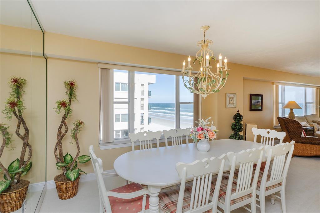 4631 South Atlantic Avenue, Unit 8601 Ponce Inlet, FL 32127 - Photo 42 of 64 a dining room with chandelier and wooden floor