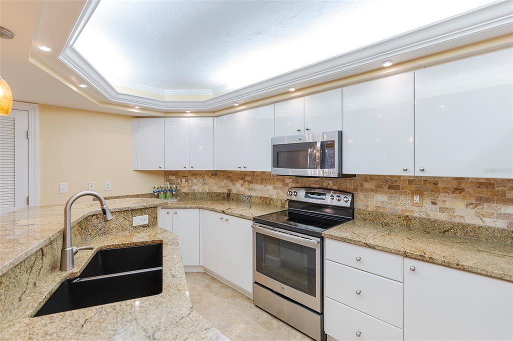 4631 South Atlantic Avenue, Unit 8601 Ponce Inlet, FL 32127 - Photo 51 of 64 a kitchen with stainless steel appliances granite countertop a sink and cabinets