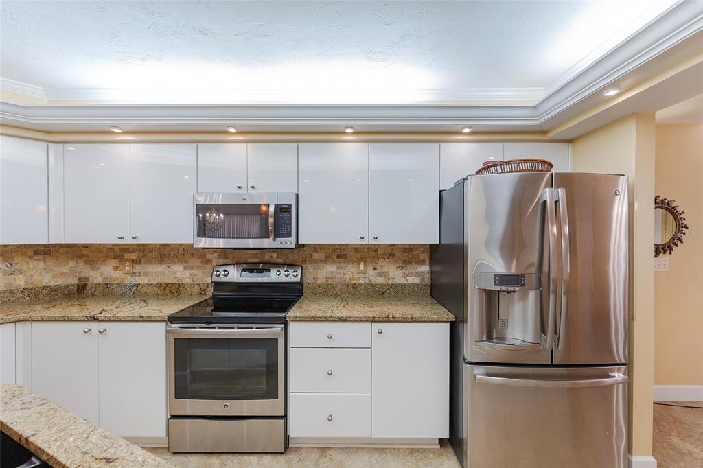 4631 South Atlantic Avenue, Unit 8601 Ponce Inlet, FL 32127 - Photo 53 of 64 a kitchen with granite countertop a refrigerator and a stove top oven