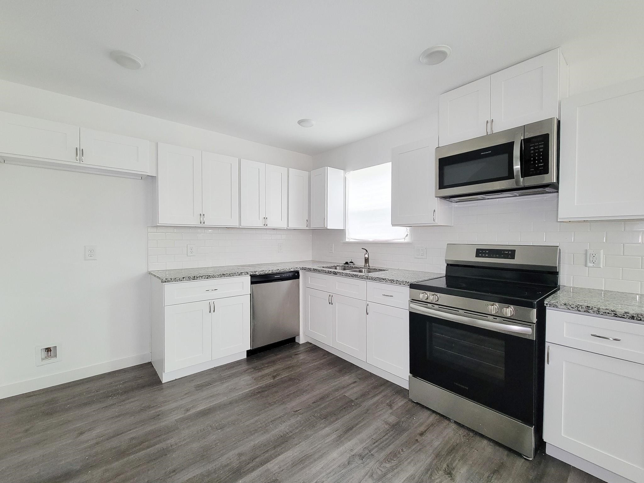 8122 Sterlingshire Street, Unit B Houston, TX 77078 - Photo 5 of 24 a kitchen with granite countertop a sink cabinets and stainless steel appliances