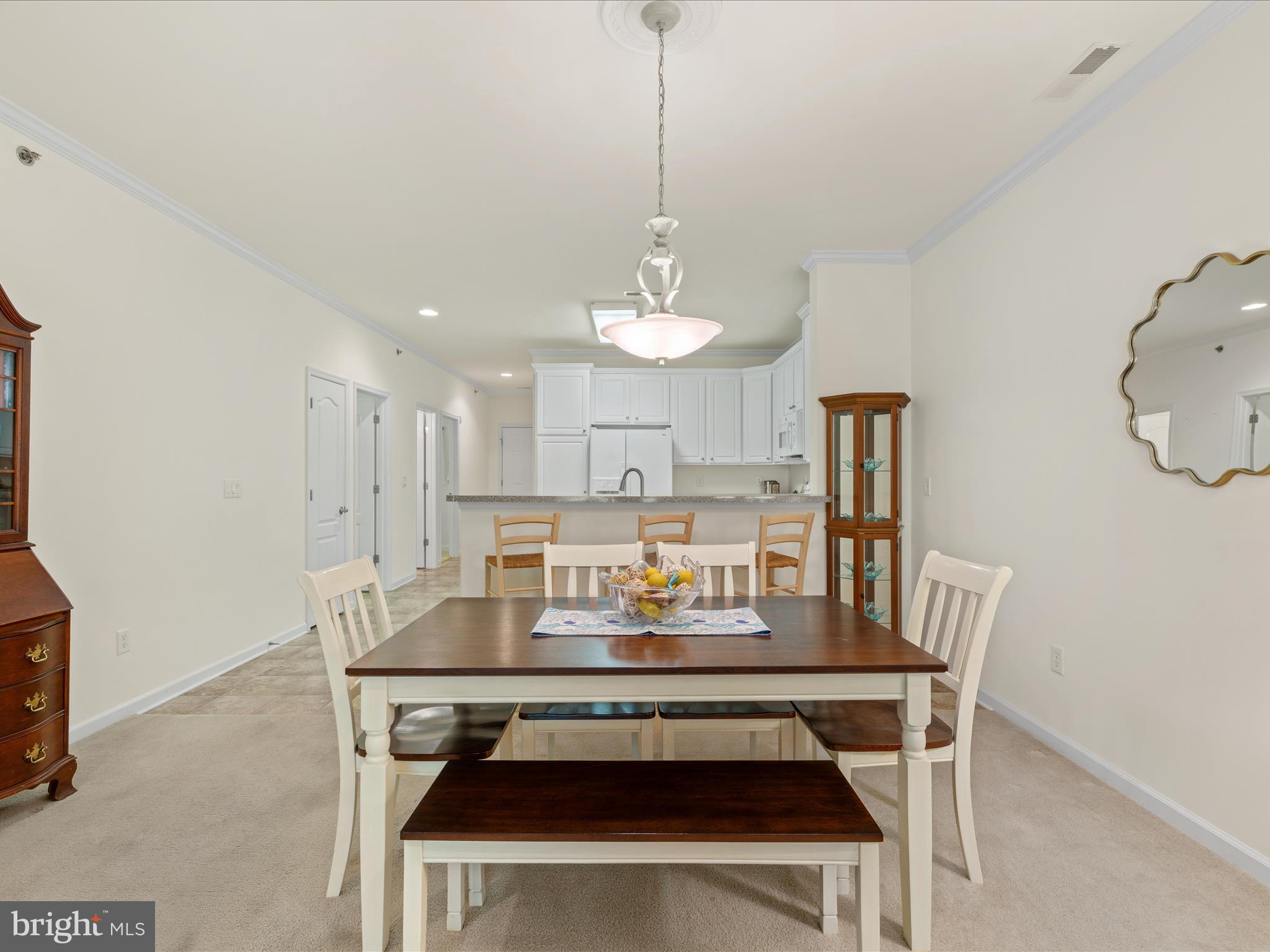 30413 Cedar Neck Road, Unit 304 Ocean View, DE 19970 - Photo 11 of 46 a dining room with wooden floor a chandelier a wooden table and chairs