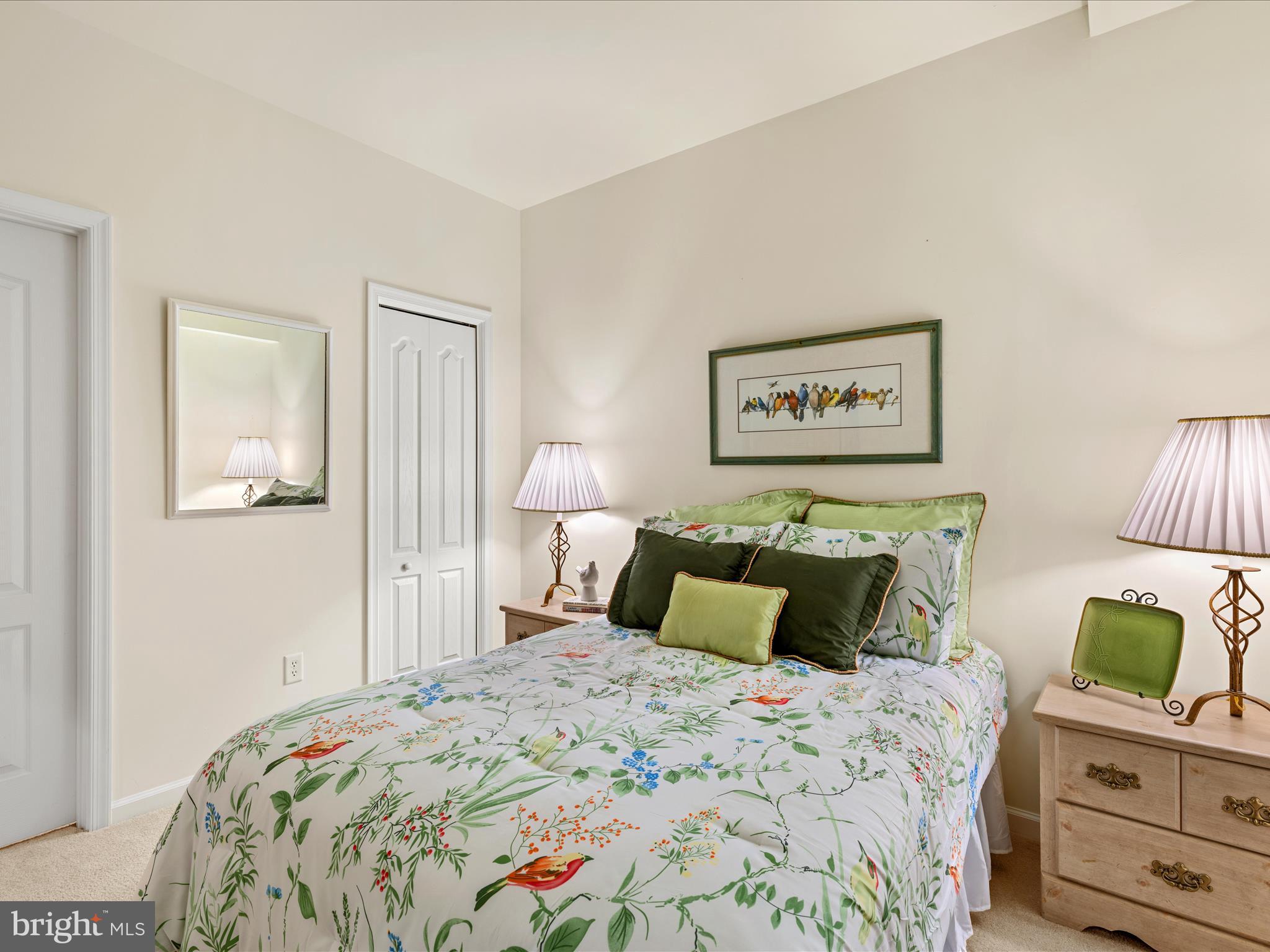 30413 Cedar Neck Road, Unit 304 Ocean View, DE 19970 - Photo 24 of 46 a bedroom with a bed and a lamp on dresser