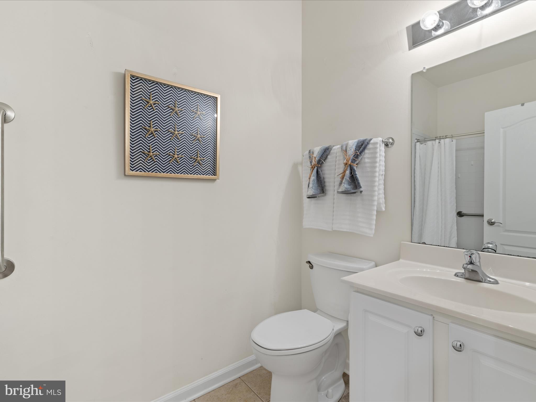 30413 Cedar Neck Road, Unit 304 Ocean View, DE 19970 - Photo 30 of 46 a bathroom with a toilet sink and mirror
