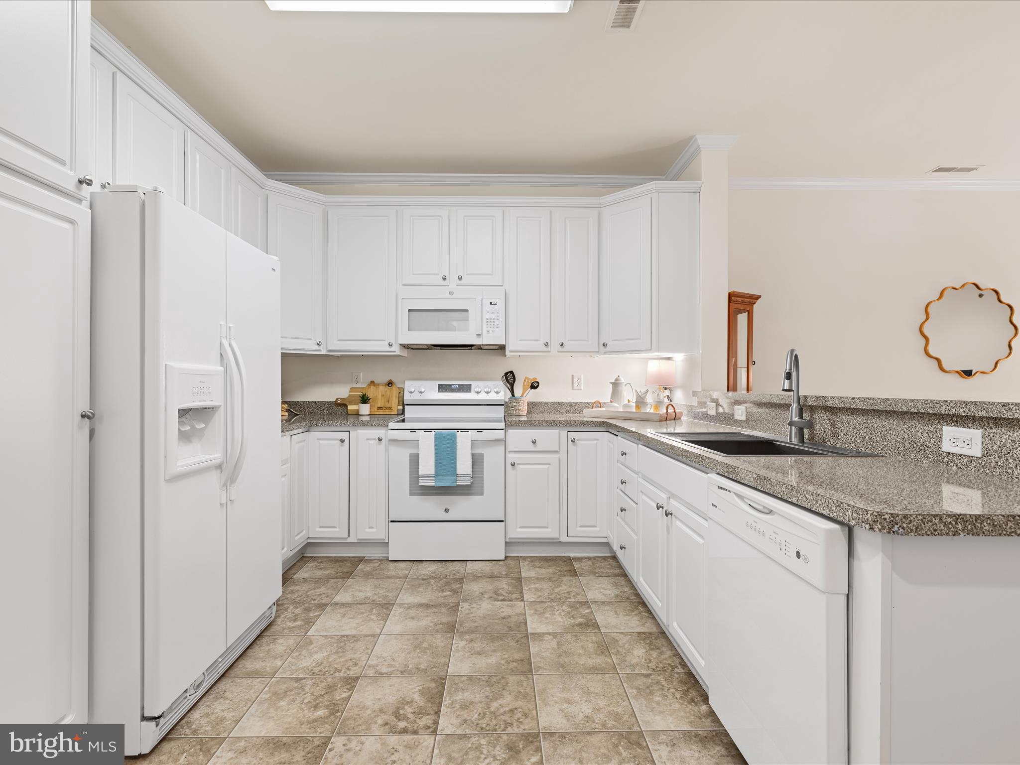 30413 Cedar Neck Road, Unit 304 Ocean View, DE 19970 - Photo 9 of 46 a kitchen with granite countertop a refrigerator sink and cabinets