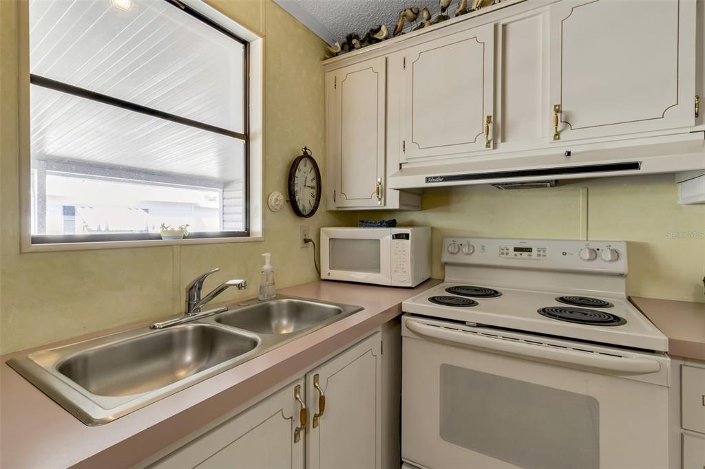 10315 Cortez Road West, Unit 26J Bradenton, FL 34210 - Photo 16 of 69 a kitchen with granite countertop a sink a stove and cabinets