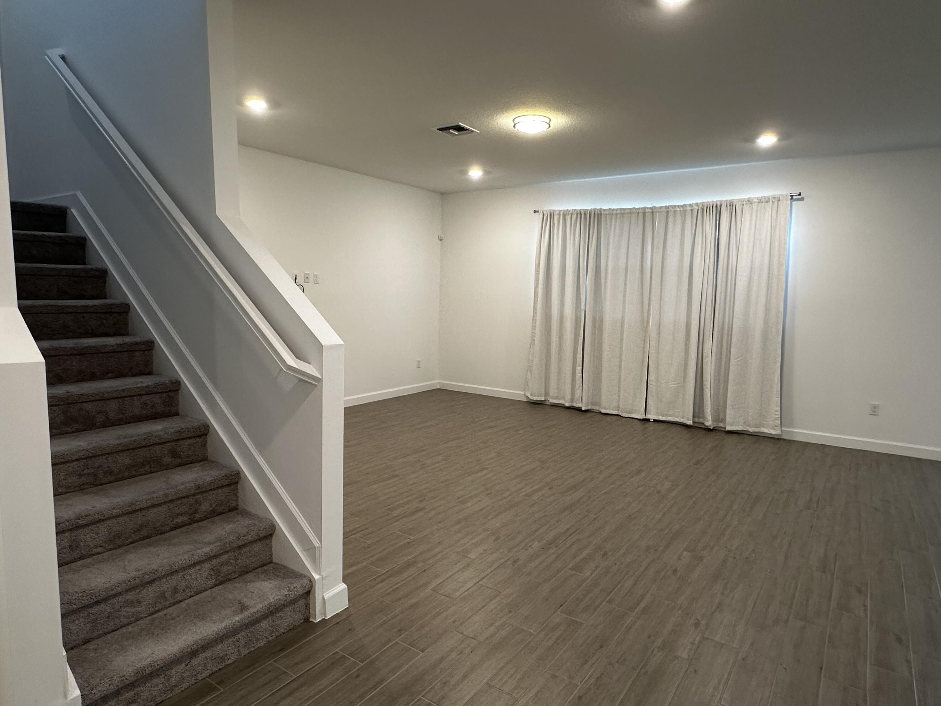 3507 Bauer Road Royal Palm Beach, FL 33411 - Photo 12 of 26 wooden floor in an empty room with stairs