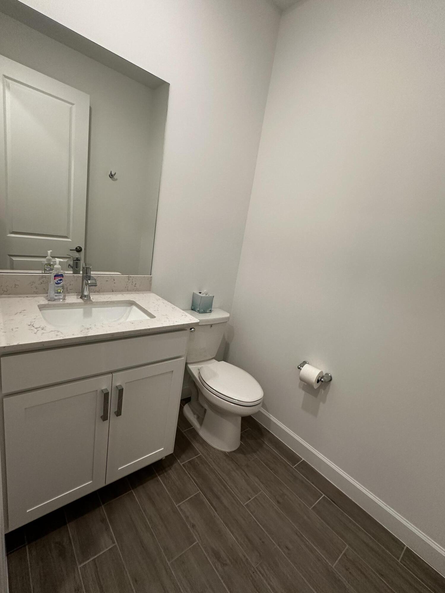 3507 Bauer Road Royal Palm Beach, FL 33411 - Photo 13 of 26 a bathroom with a toilet a sink and mirror