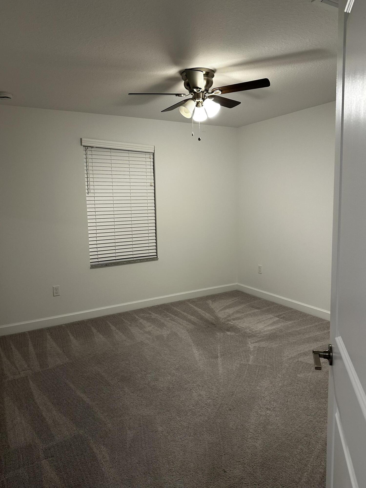 3507 Bauer Road Royal Palm Beach, FL 33411 - Photo 19 of 26 an empty room with a chandelier fan and windows