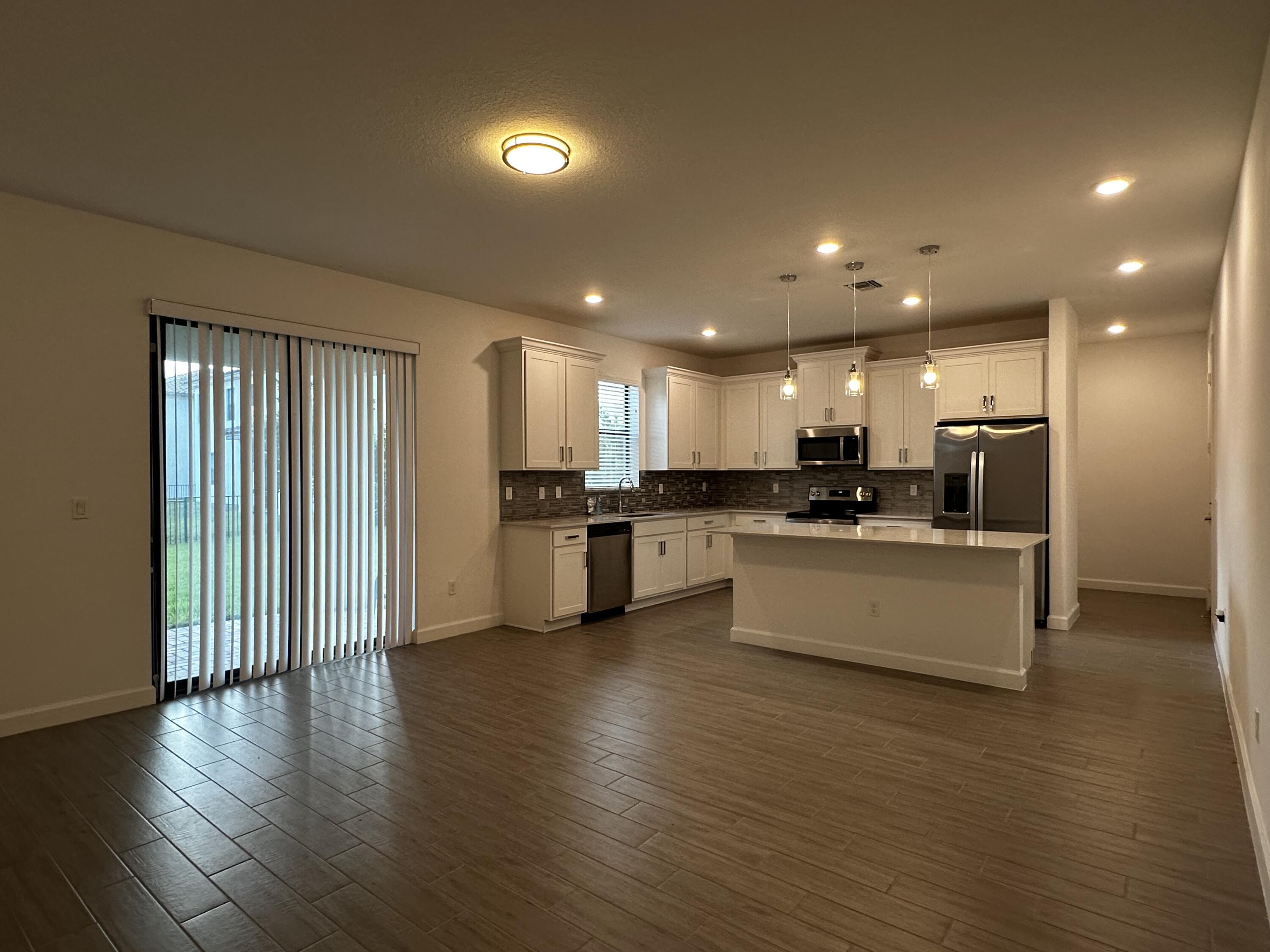 3507 Bauer Road Royal Palm Beach, FL 33411 - Photo 7 of 26 a large kitchen with stainless steel appliances kitchen island wooden cabinets and a sink