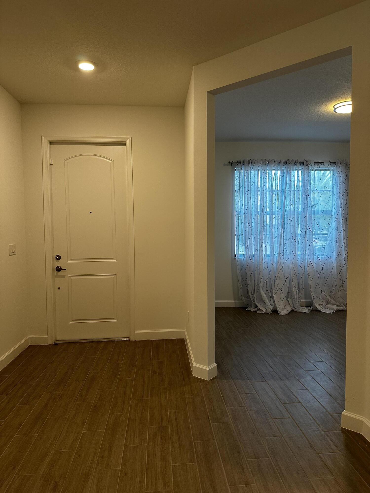 3507 Bauer Road Royal Palm Beach, FL 33411 - Photo 10 of 26 an empty room with wooden floor and windows