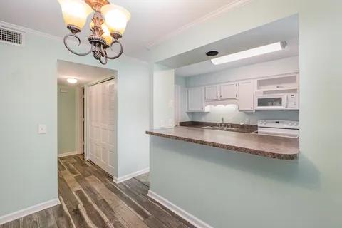 a kitchen with a refrigerator and white cabinets