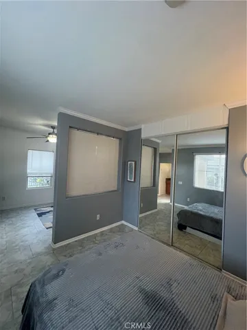 a spacious bedroom with a bed and a mirror