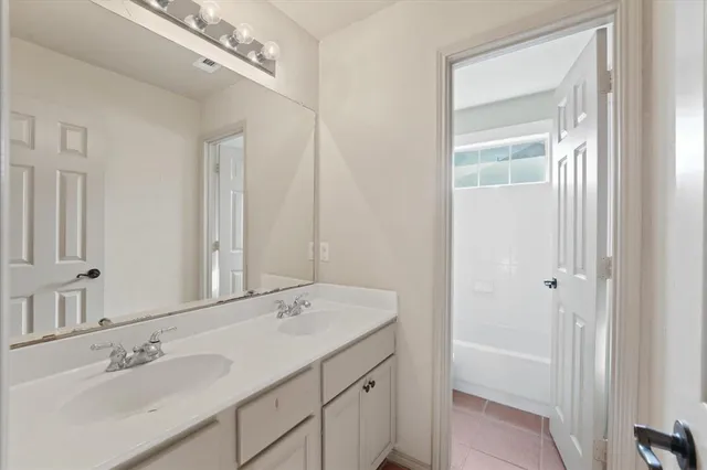 a spacious bathroom with a double vanity sink mirror and double