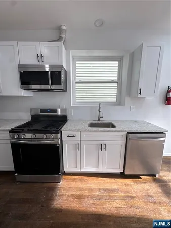 a kitchen with stainless steel appliances a stove a sink and a microwave