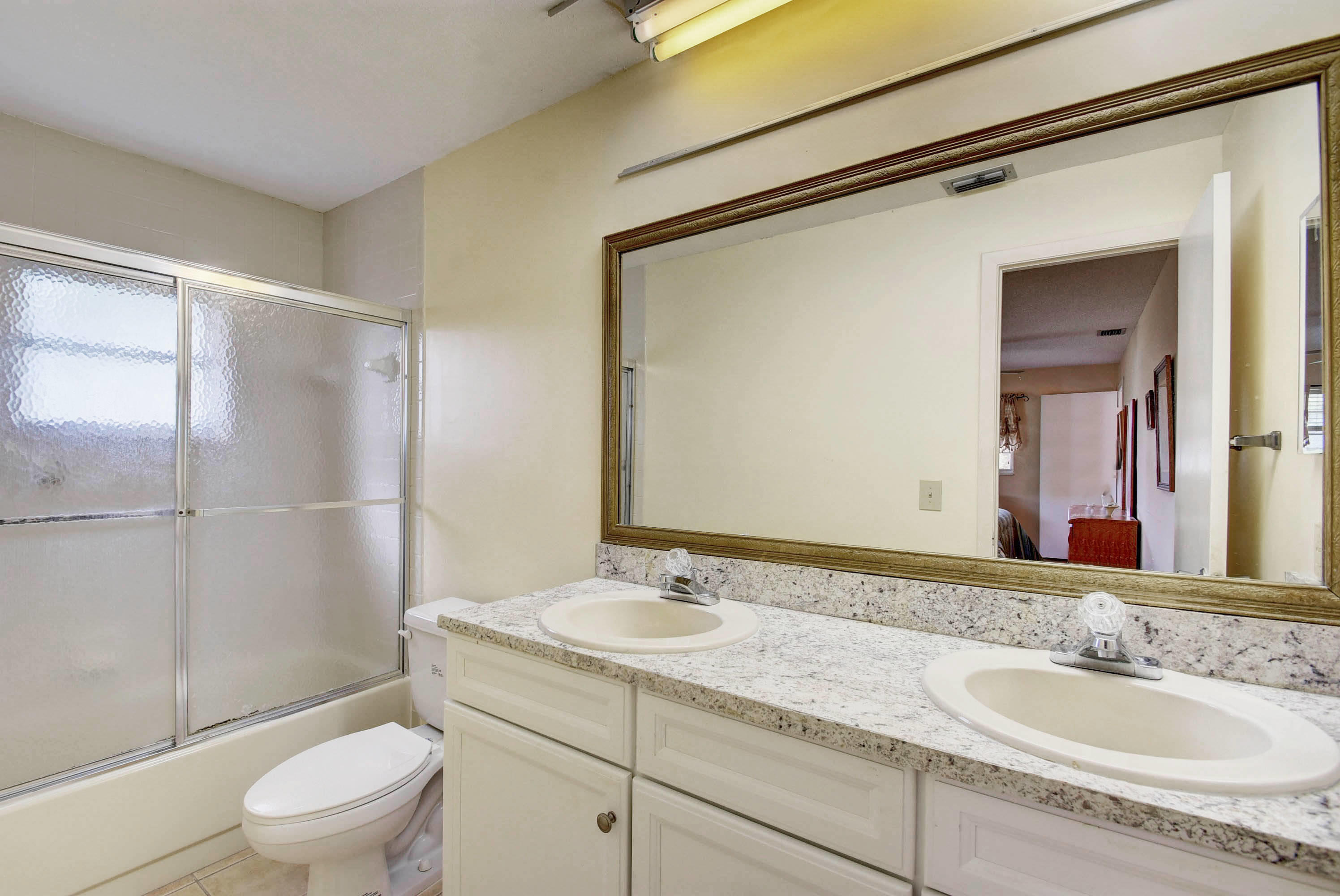 6295 Dusenburg Road Delray Beach, FL 33484 - Photo 29 of 34 a bathroom with a granite countertop sink toilet and shower