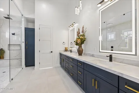 a bathroom with a double vanity sink toilet and shower