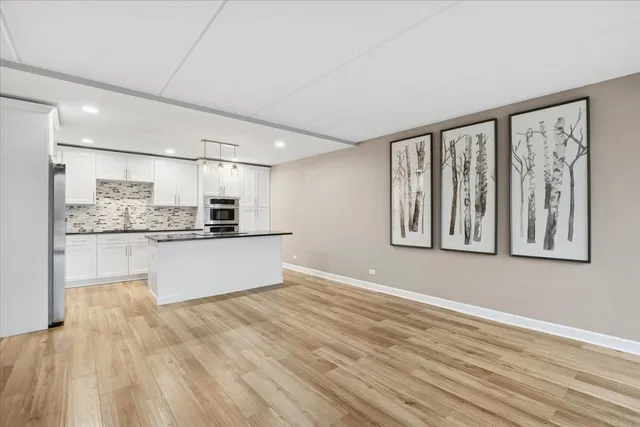 a large kitchen with kitchen island wooden floors and stainless steel appliances