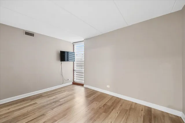 a view of an empty room with wooden floor