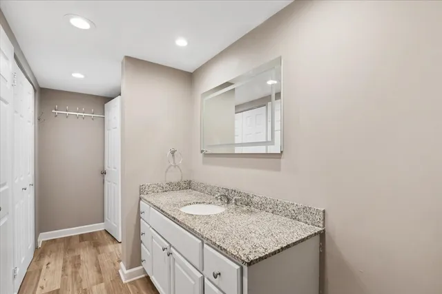 a bathroom with a granite countertop sink and a mirror