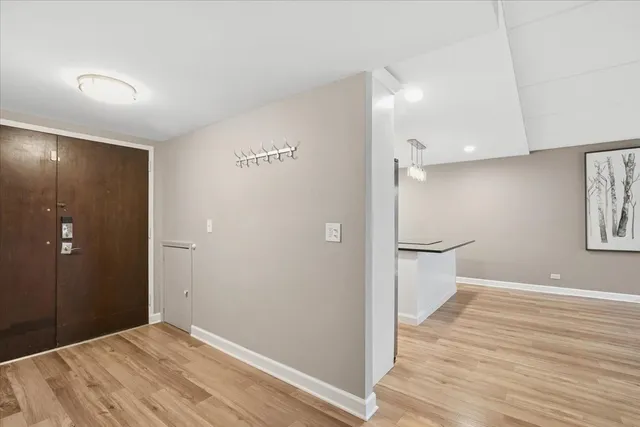 a view of empty room with wooden floor and bathroom