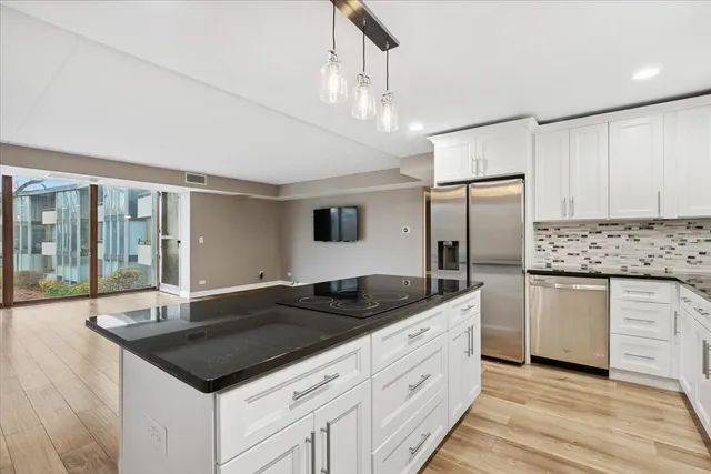 a kitchen with granite countertop a sink cabinets and stainless steel appliances