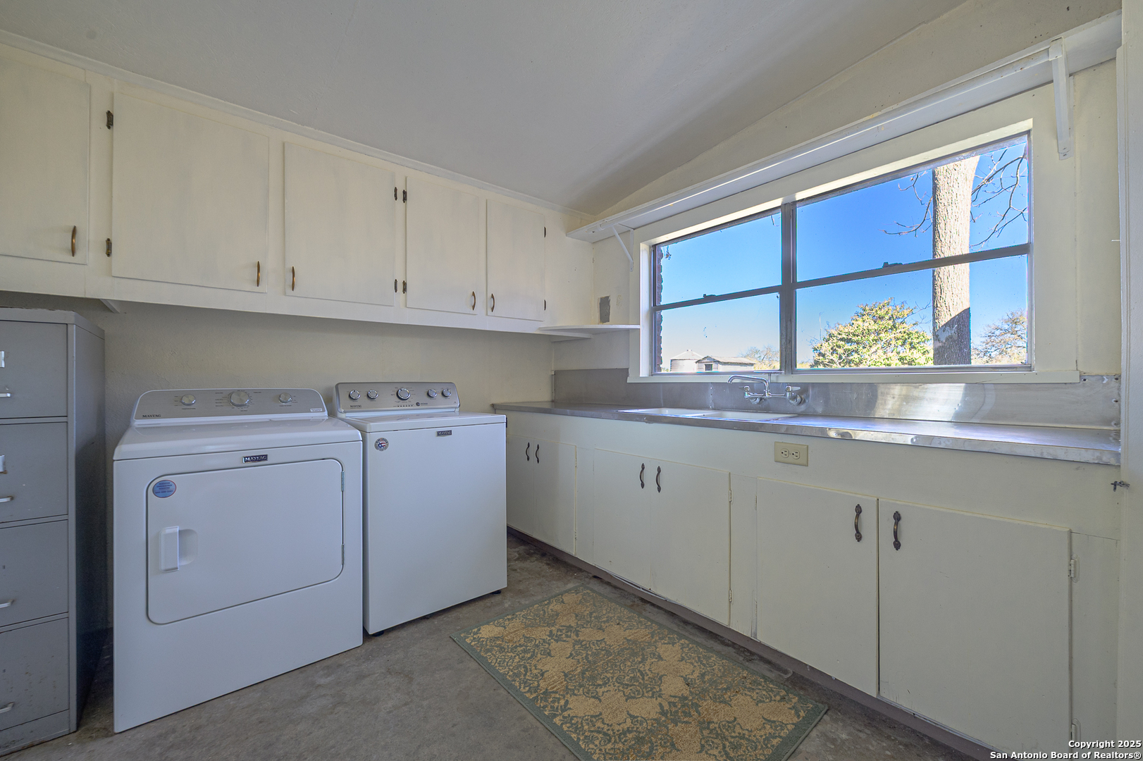 1173 Charco Road Beeville, TX 78102 - Photo 24 of 39 a room with dryer and cabinets