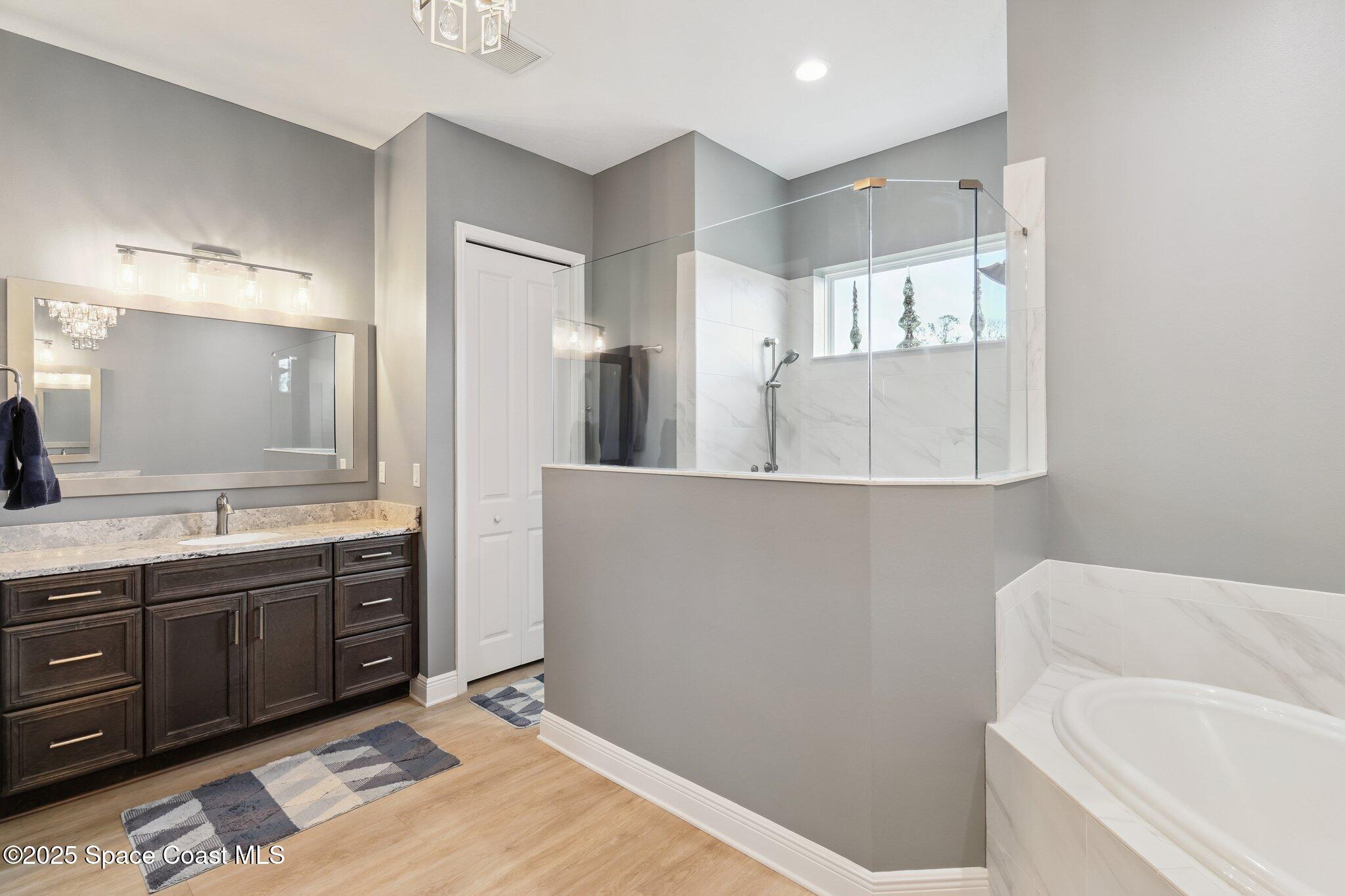 4437 Preservation Circle Melbourne, FL 32934 - Photo 12 of 40 a bathroom with a tub sink and mirror