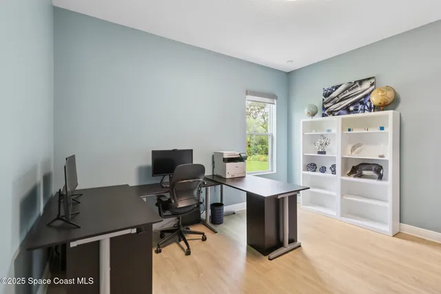 a view of a workspace with furniture and a window