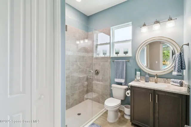 a bathroom with a granite countertop toilet a sink and a mirror