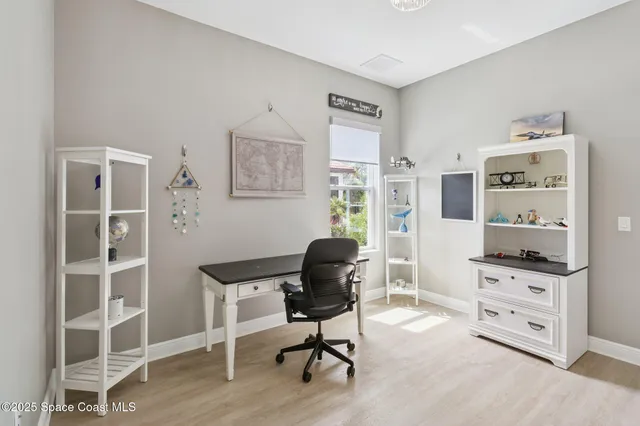 a view of a workspace with furniture and a window