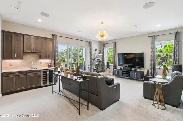 a living room with stainless steel appliances granite countertop furniture a flat screen tv and a large window