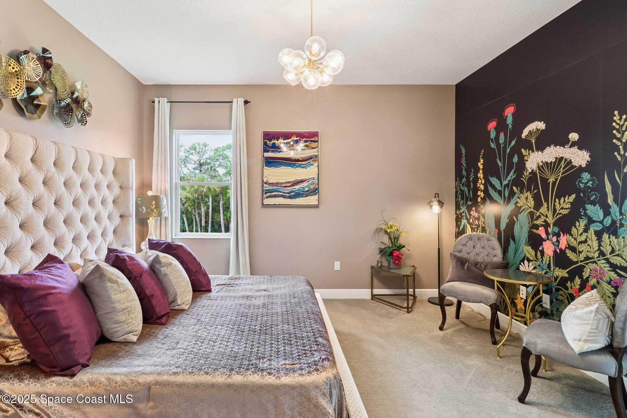 4437 Preservation Circle Melbourne, FL 32934 - Photo 20 of 40 a bedroom with a bed and a chandelier