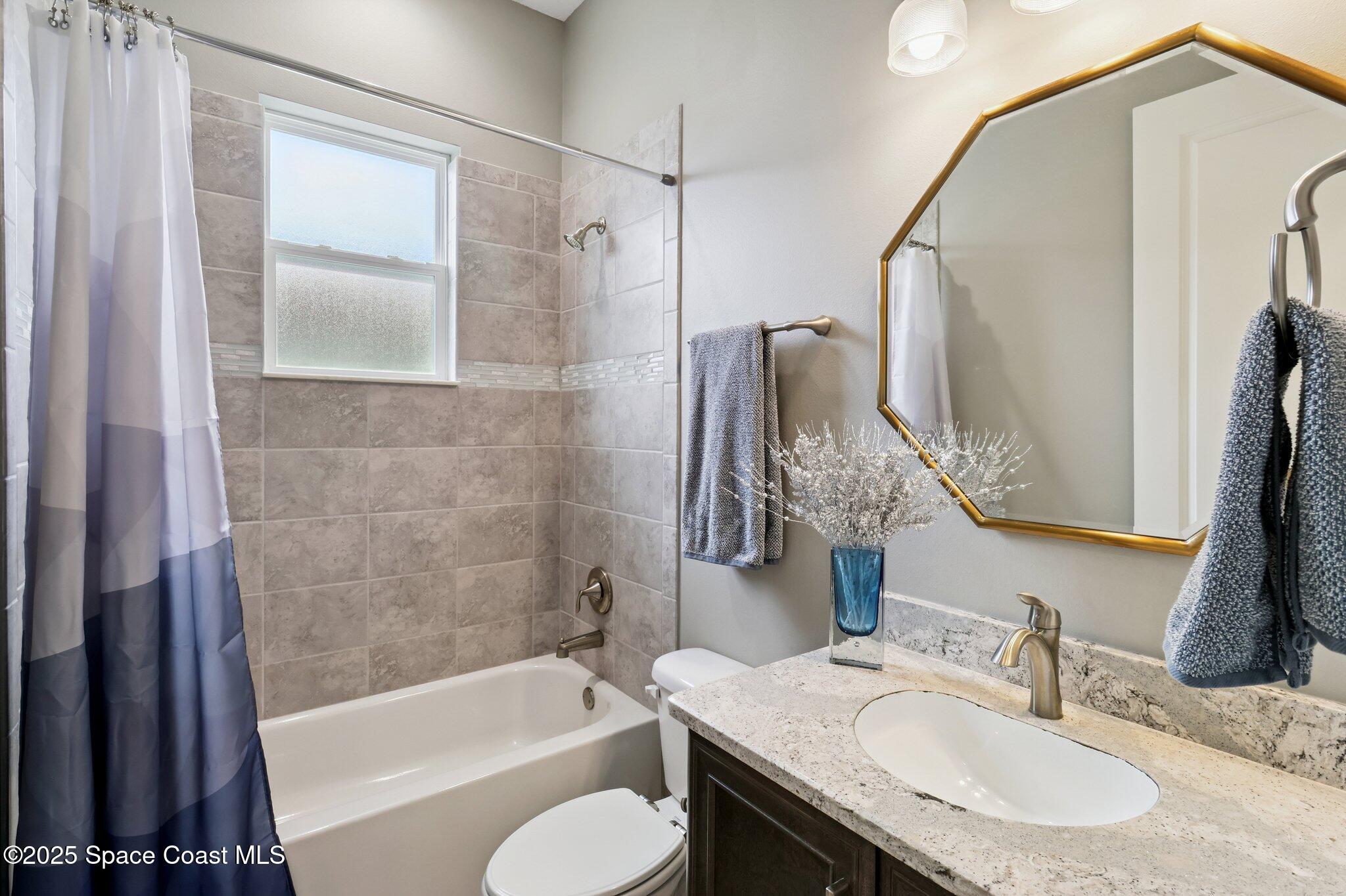 4437 Preservation Circle Melbourne, FL 32934 - Photo 21 of 40 a bathroom with a granite countertop sink toilet and shower