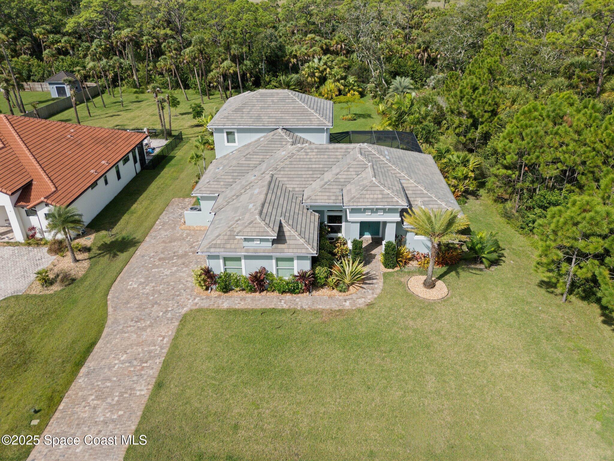 4437 Preservation Circle Melbourne, FL 32934 - Photo 33 of 40 an aerial view of a house with swimming pool and large trees