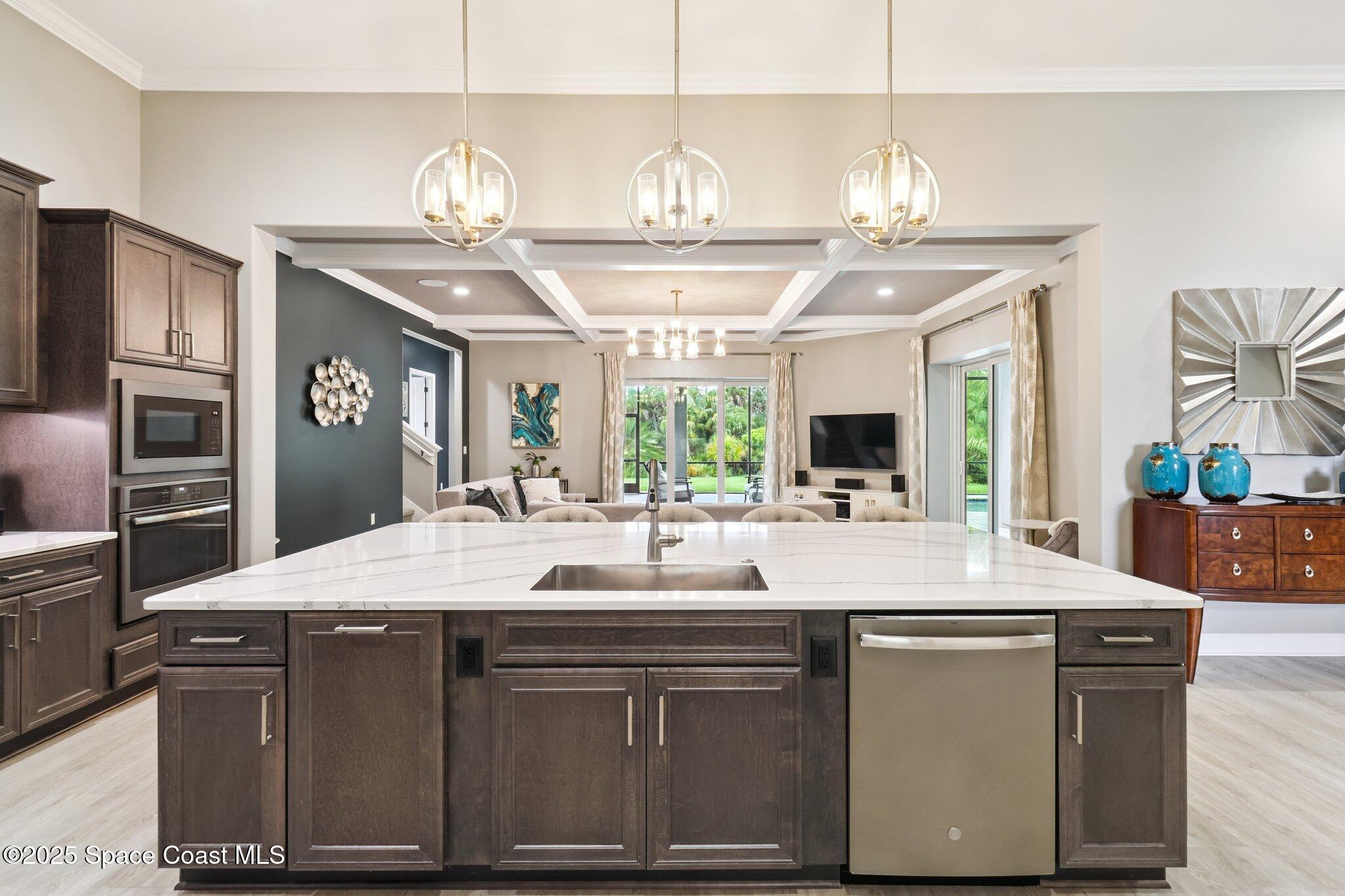 4437 Preservation Circle Melbourne, FL 32934 - Photo 5 of 40 a kitchen with kitchen island granite countertop a sink cabinets and stainless steel appliances