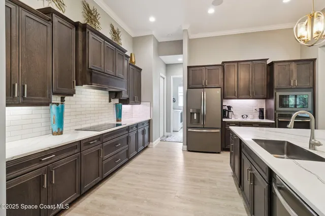 a kitchen with stainless steel appliances granite countertop a sink refrigerator and cabinets
