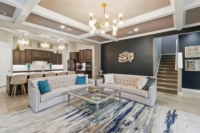 a living room with furniture and a chandelier