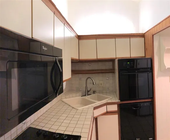 a kitchen with a sink a refrigerator and cabinets