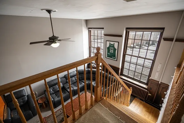 a view of staircase with wooden floor and fan