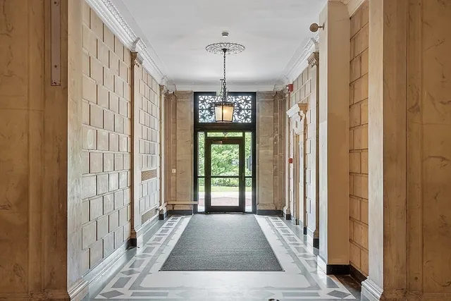 a view of a hallway with windows and chandelier