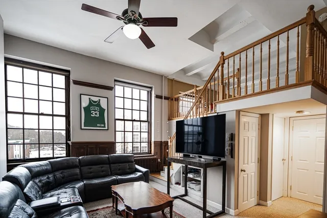 a living room with furniture a flat screen tv and a window
