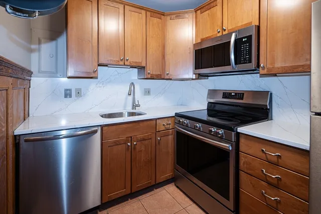 a kitchen with stainless steel appliances granite countertop a stove a refrigerator and a microwave