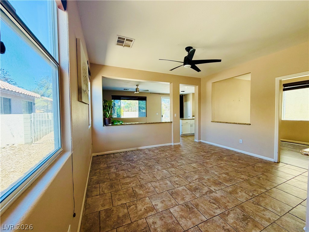 3936 Gold Point Street Las Vegas, NV 89129 - Photo 19 of 23 A spacious living area with tile flooring seamlessly connects to the kitchen, offering an open concept design.
